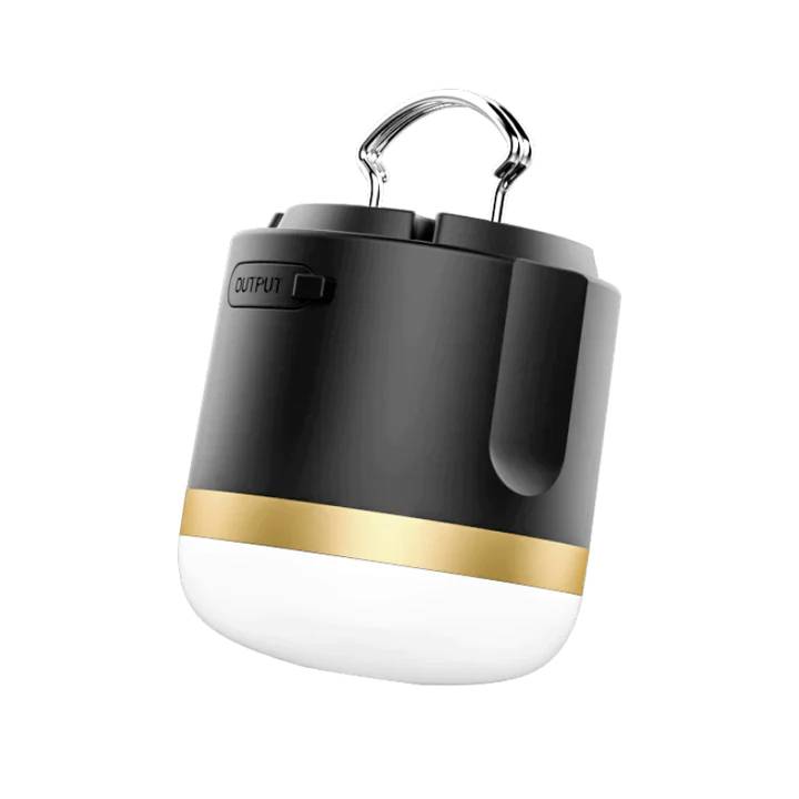 Eine tragbare LED-Campinglampe in Schwarz und Gold mit Aufhängegriff. Oben befindet sich ein "OUTPUT"-Anschluss.