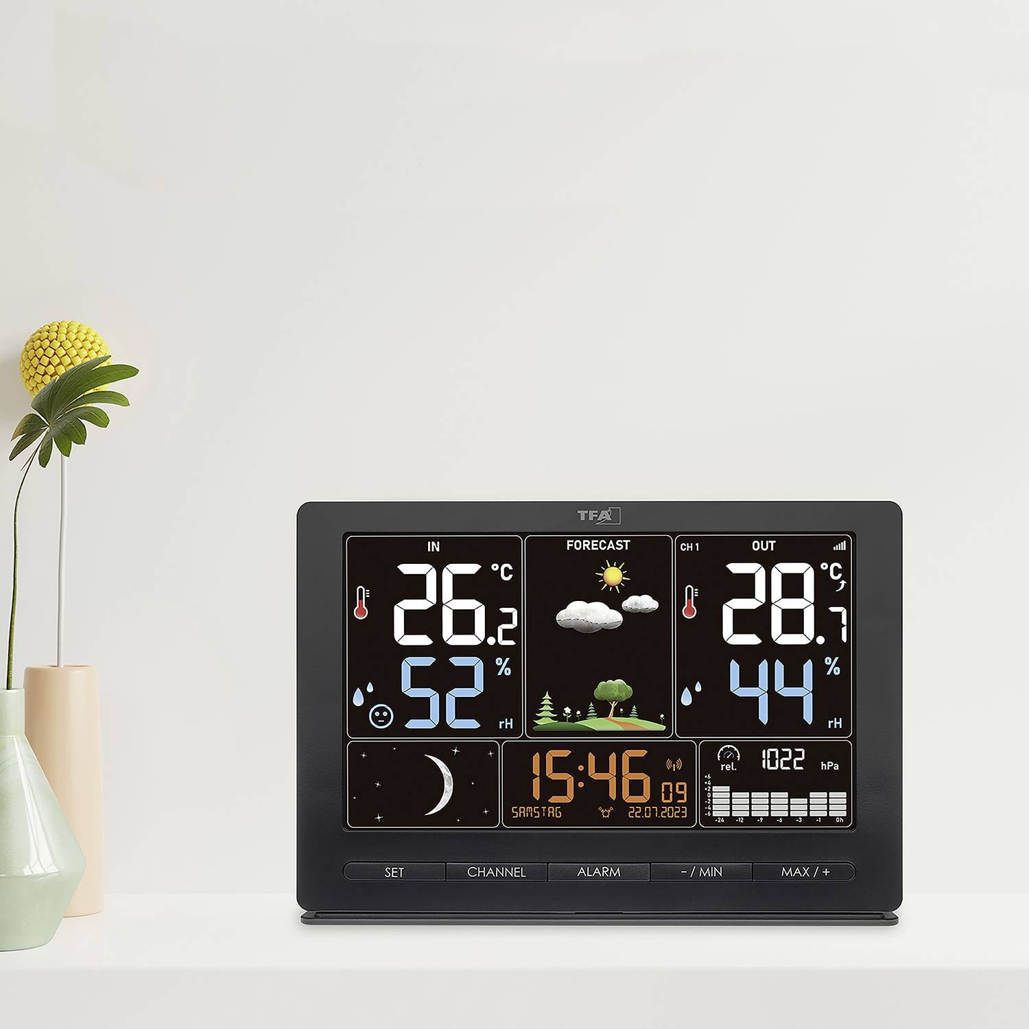 Digitales Wetterstation-Display zeigt Innen- und Außentemperatur, -feuchtigkeit, Wettervorhersage (bewölkt), Uhrzeit und Datum.