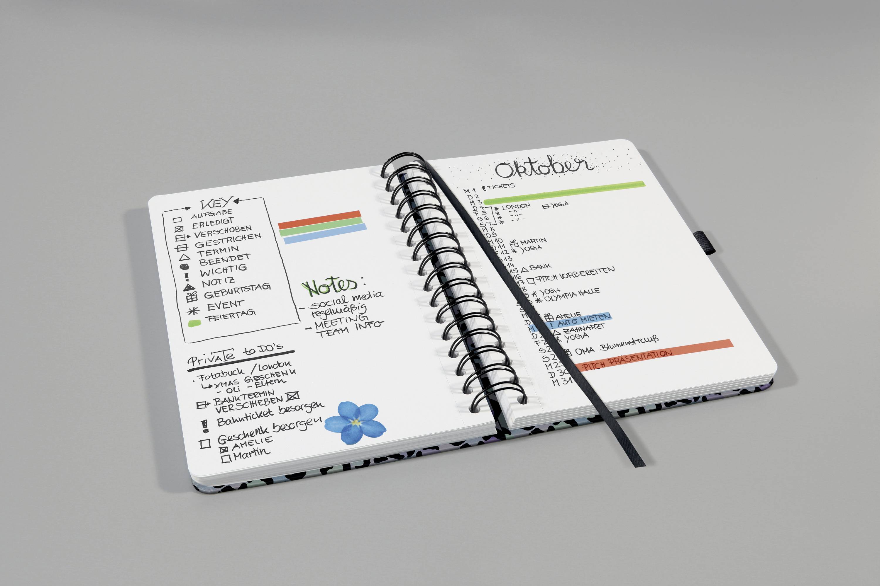 Ein geöffneter Planer mit handgeschriebenen Notizen und Listen für Oktober. Links Aufgaben und Termine; rechts ein Kalender.