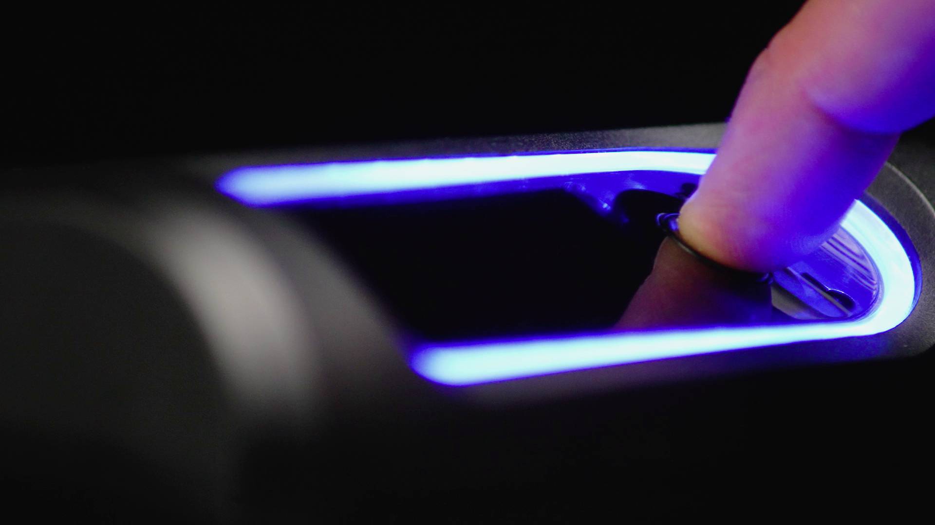 Finger auf einem beleuchteten Fingerabdruckscanner platziert.