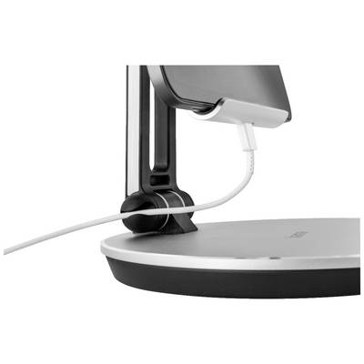 Ein Smartphone steht in einer Halterung und wird über ein Kabel aufgeladen.