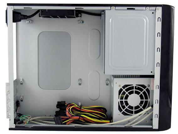 Innenansicht eines leeren Computergehäuses mit montiertem Netzteil und Kabeln, aber ohne weitere Hardware-Komponenten.