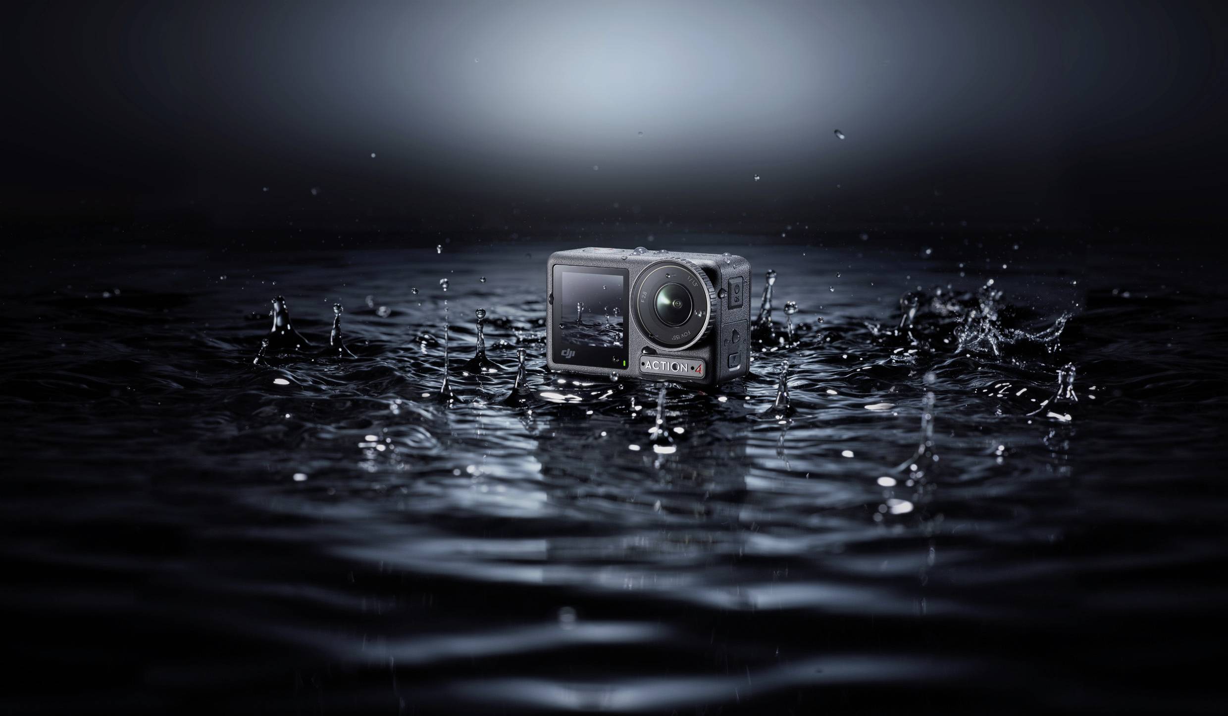 Eine Kamera liegt auf der Wasseroberfläche, während Wassertropfen spritzen. Die Szene ist in dunklen Tönen gehalten, was sie dramatisch wirken lässt.