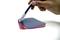 Eine Hand hält einen Stift und zeigt auf drei übereinanderliegende, verschiedenfarbige transparente Folien auf einer weißen Oberfläche.