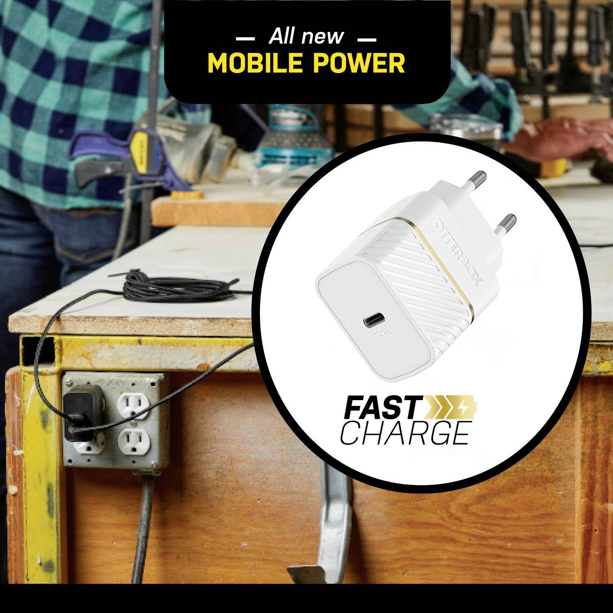 Ein Ladegerät für die Steckdose wirbt mit 'Fast Charge' Feature und der Text 'All New Mobile Power' auf einer Werkbank.
