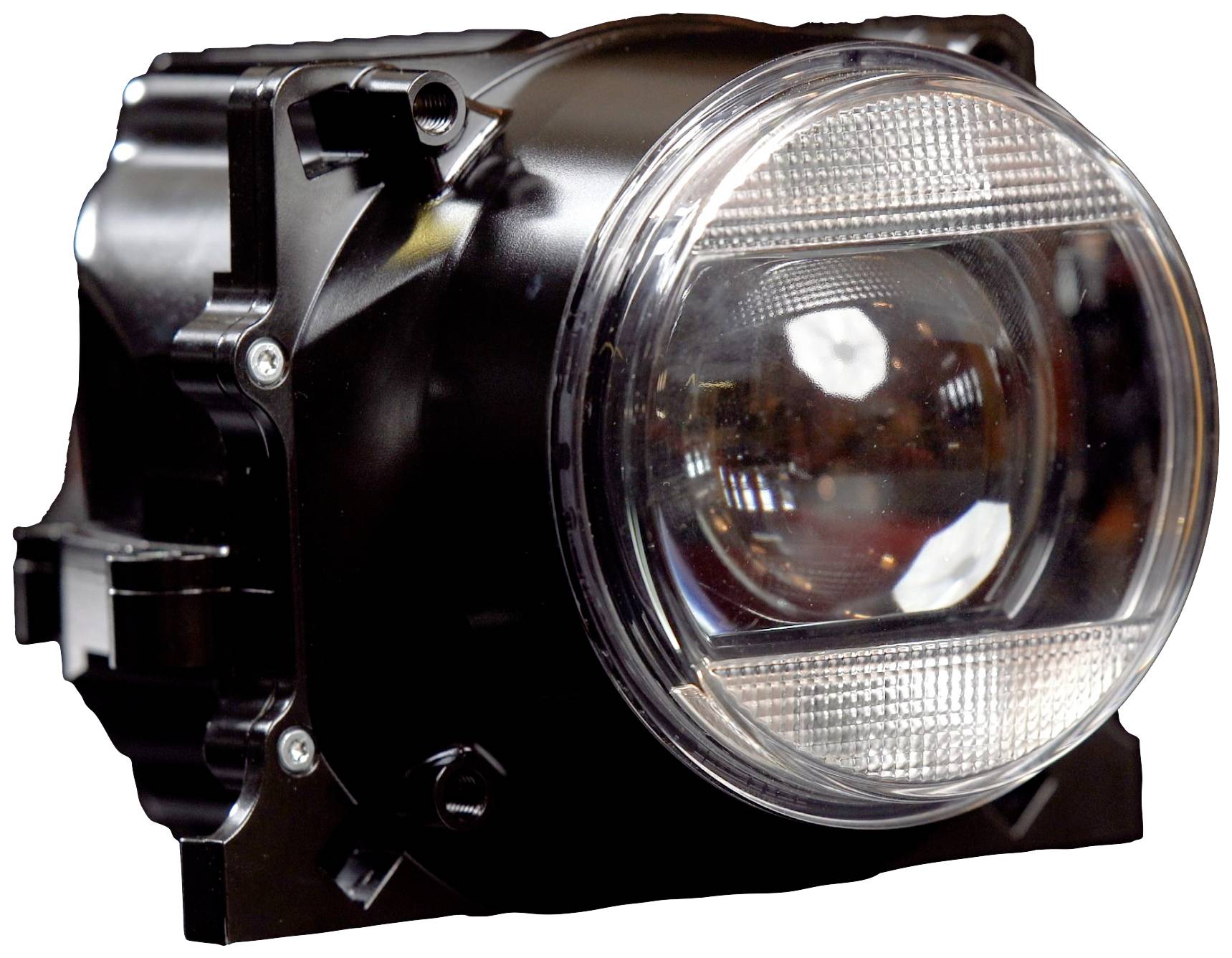 Ein einzelner runder Autoscheinwerfer in einem schwarzen Gehäuse, frontal aufgenommen. Der Scheinwerfer hat reflektierende Elemente.