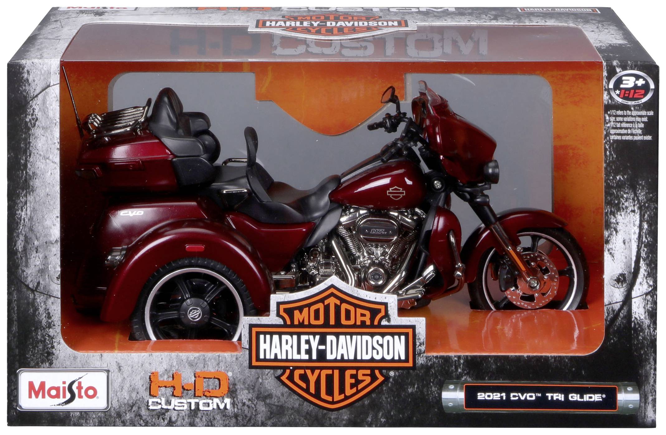 Modell eines Harley-Davidson-Trikes mit rotem Lack in einer Schachtel. Verpackung zeigt Logo und Typ: '2021 CVO Tri Glide'.