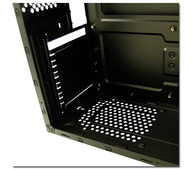 Innerer Teil eines leeren Computergehäuses, schwarz, mit mehreren Lüftungsschlitzen und Platz für Hardwarekomponenten.