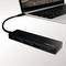 Ein schwarzes USB-Hub mit mehreren Anschlüssen ist an einen Laptop angeschlossen.