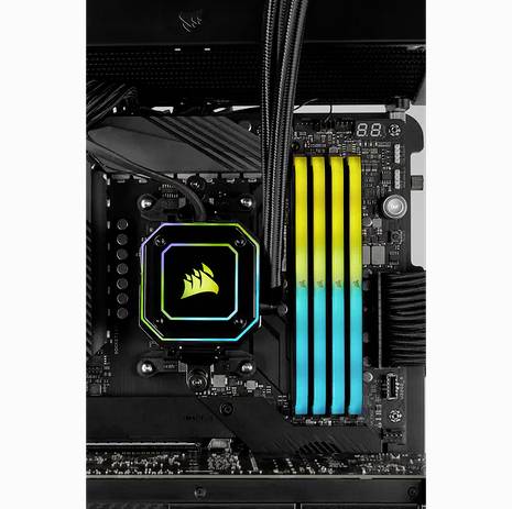Ein PC-Motherboard mit einer beleuchteten CPU-Kühlung und vier leuchtenden RAM-Sticks in gelber und blauer Farbe.