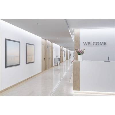 Moderner Empfangsbereich mit Holzverkleidungen und schlichtem Design. An der Wand hängt ein Schild mit der Aufschrift 'WELCOME'.
