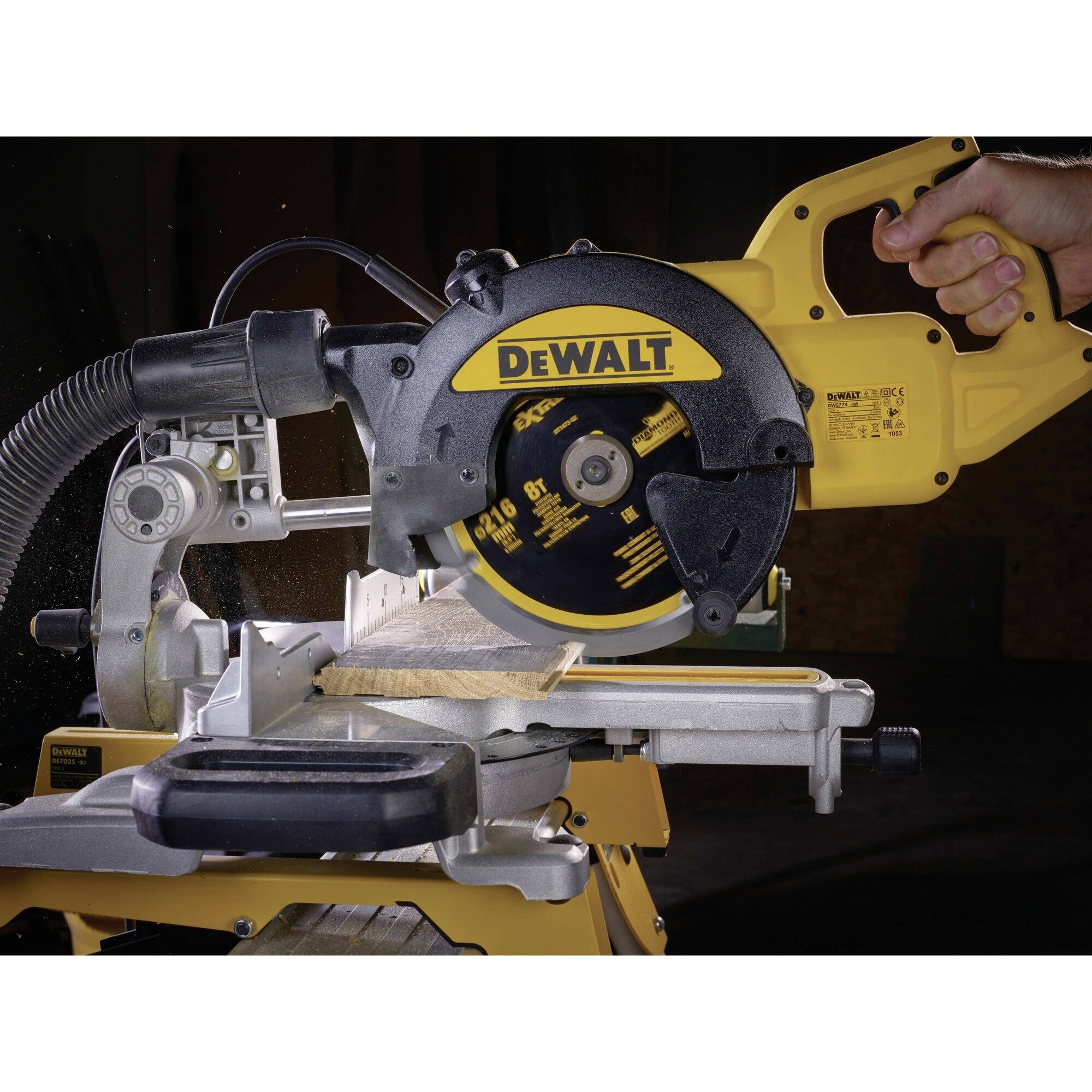 Eine gelbe Kappsäge wird mit einer Hand bedient. Das DeWALT-Logo ist sichtbar. Holz wird präzise geschnitten.