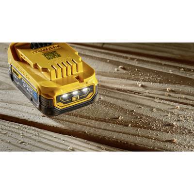 Akkubohrmaschine-Akku auf einem Holztisch mit Holzspänen im Vordergrund.