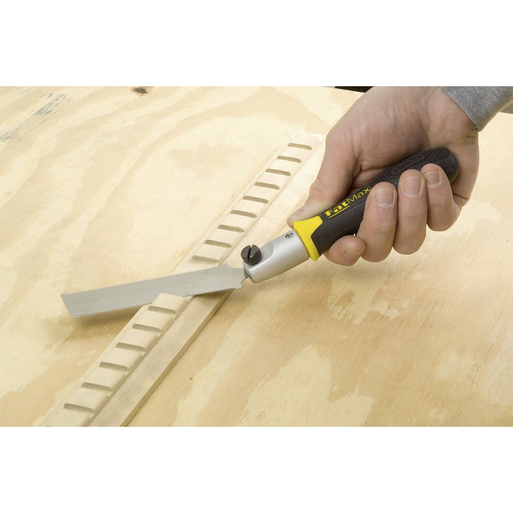 Eine Hand hält eine kleine Säge und schneidet präzise eine Kerbe in ein Holzbrett.