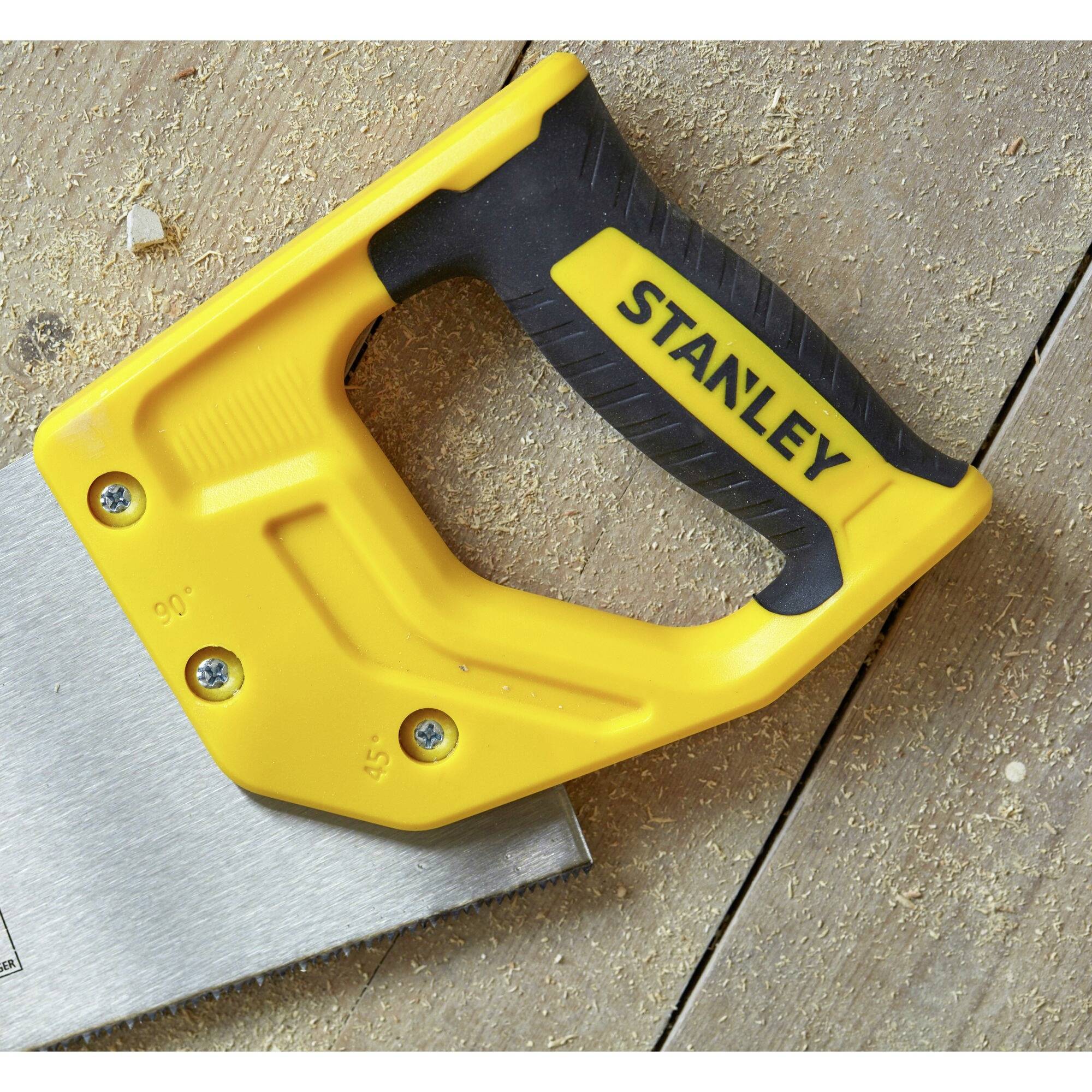 Nahaufnahme einer Säge mit ergonomischem Griff und markant gelbem Design, auf einem Holzboden liegend, Herstellername sichtbar.