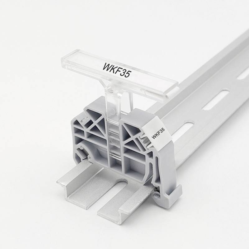 Halteclip aus Metall mit der Aufschrift 'WKF35', montiert auf einer Schiene, fotografiert vor weißem Hintergrund.