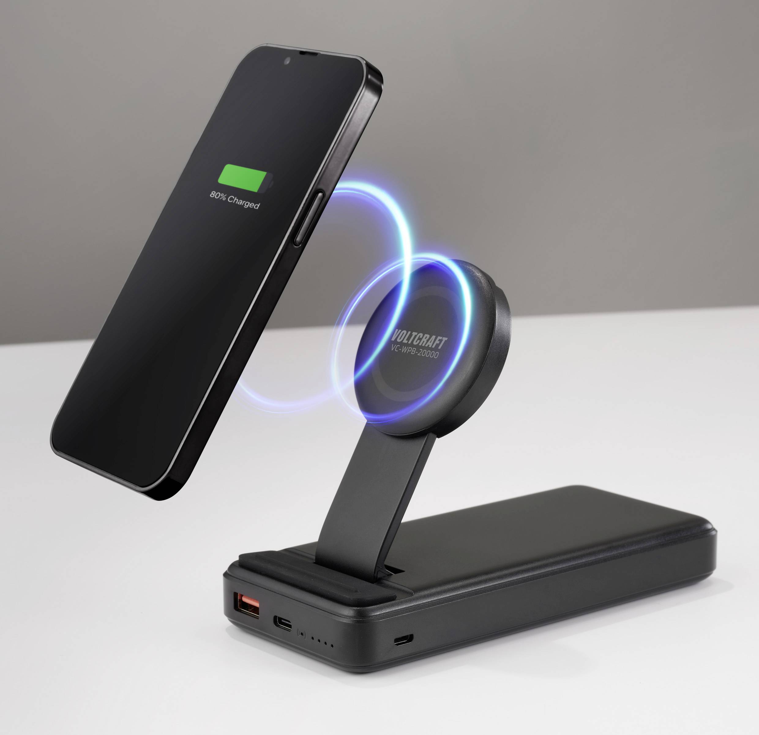 Ein schwarzes Smartphone schwebt über einem Ladegerät mit blauen Ladewellen. Der Akkuanzeige zeigt '80% geladen'.