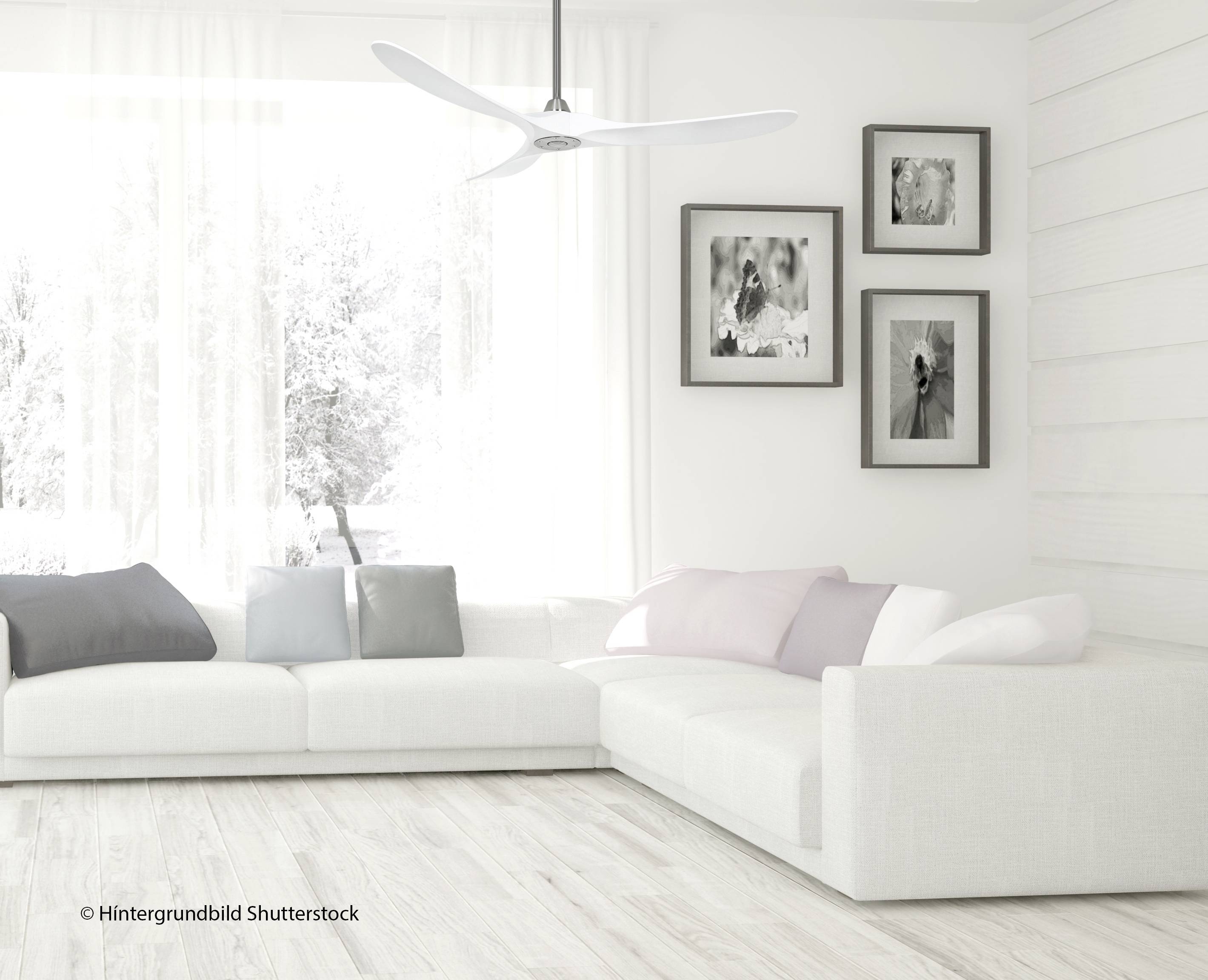 Helles Wohnzimmer mit weißem Sofa, pastellfarbenen Kissen, großem Fenster und gerahmten Bildern an weißer Wand, Deckenventilator oben.