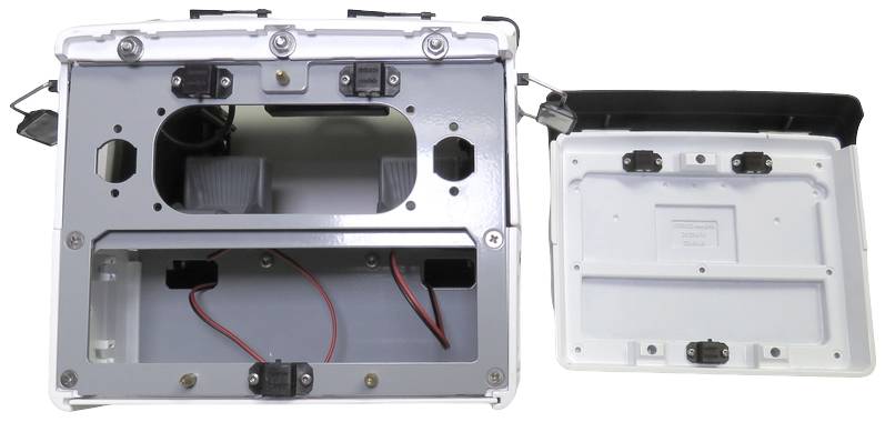Geöffnete, weiße Kiste mit Deckel daneben, innen sichtbare Kabel und Halterungen, möglicherweise Teil eines elektronischen Geräts oder Halterungssystems.