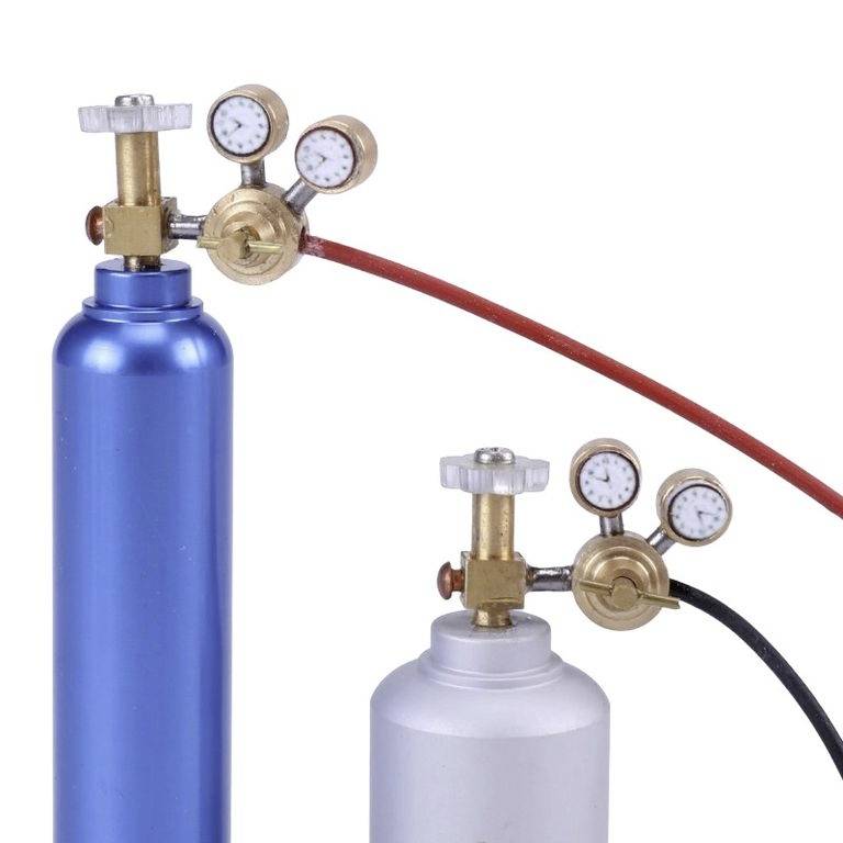 Zwei Gasflaschen mit Druckreglern und Manometern, eine blau und eine weiß, verbunden mit roten Schläuchen.