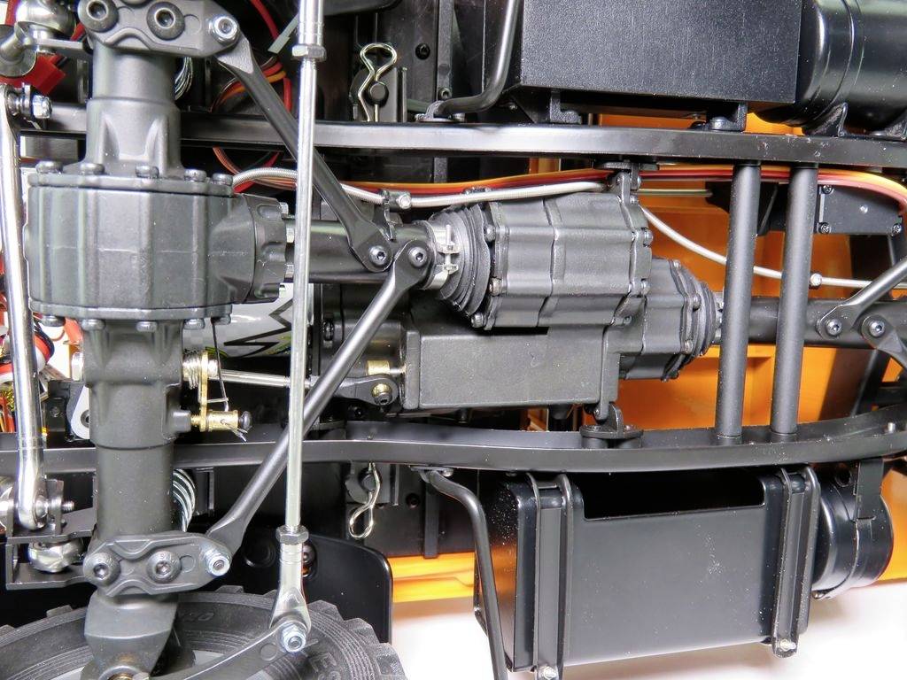 Nahaufnahme eines komplexen Getriebesystems mit sichtbaren Antriebswellen, Zahnrädern und Verbindungen in einem metallischen Rahmen.