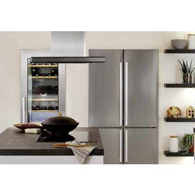 Moderne Küche mit grauen Schränken, Kühlschrank mit Doppeltür und eingebautem Weinkühler. Kochinsel mit schwarzem Topf im Vordergrund.