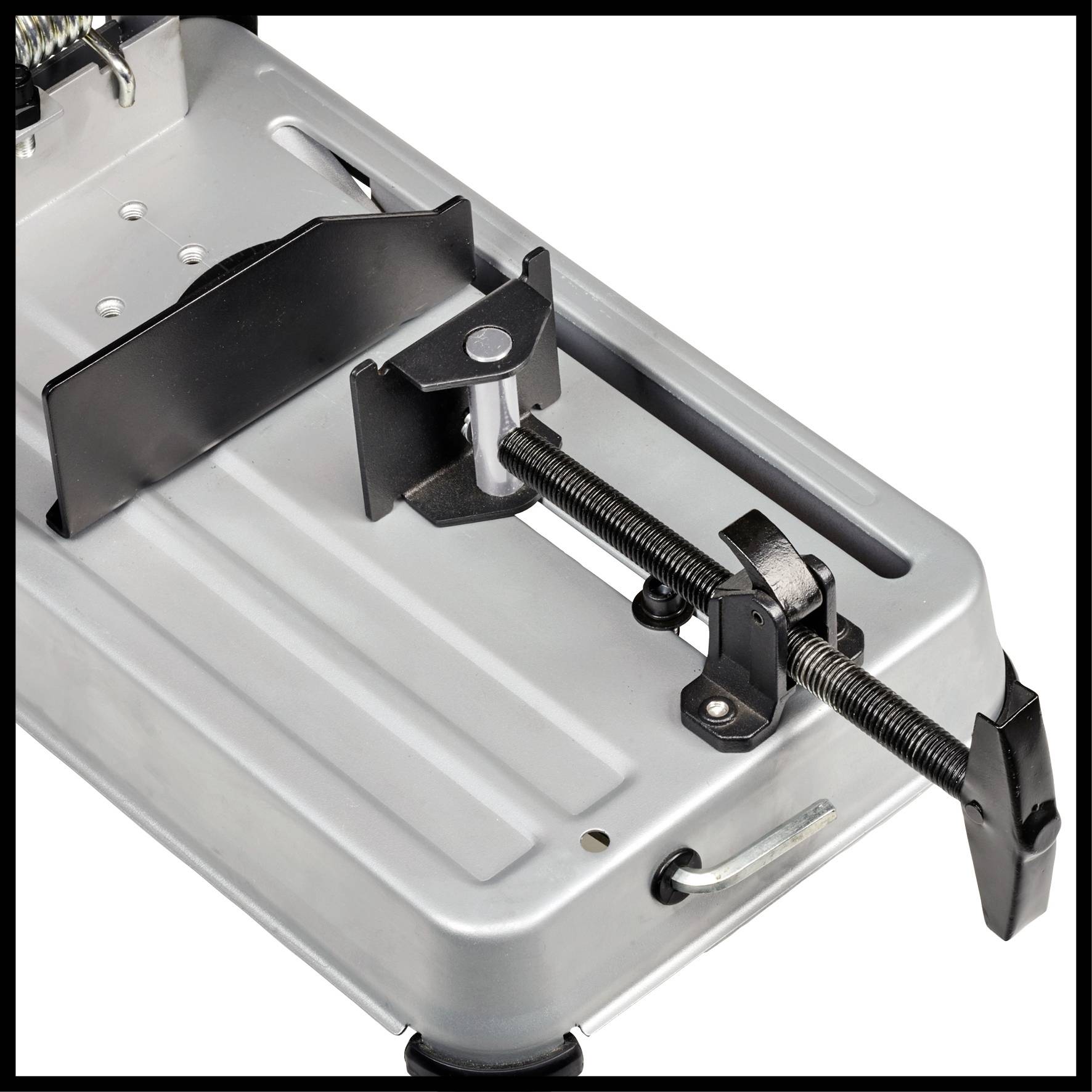 Metallschraubstock mit Spannmechanismus auf einer grauen Plattform, verwendet zur Fixierung von Werkstücken bei der Bearbeitung.