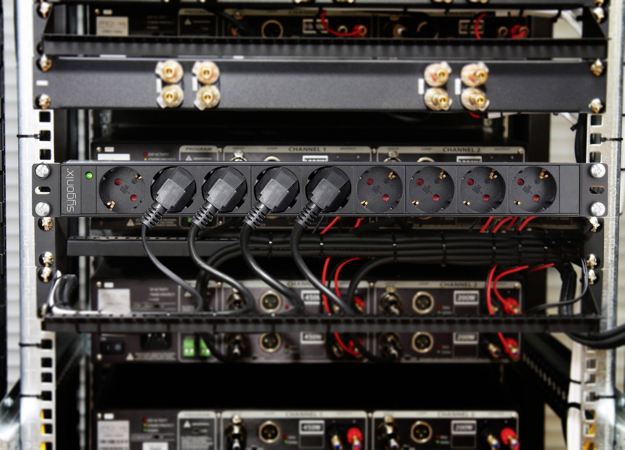 Mehrere an eine Steckdosenleiste angeschlossene Stecker in einem Server- oder Netzwerkschrank mit sichtbaren Kabeln und Anschlüssen.