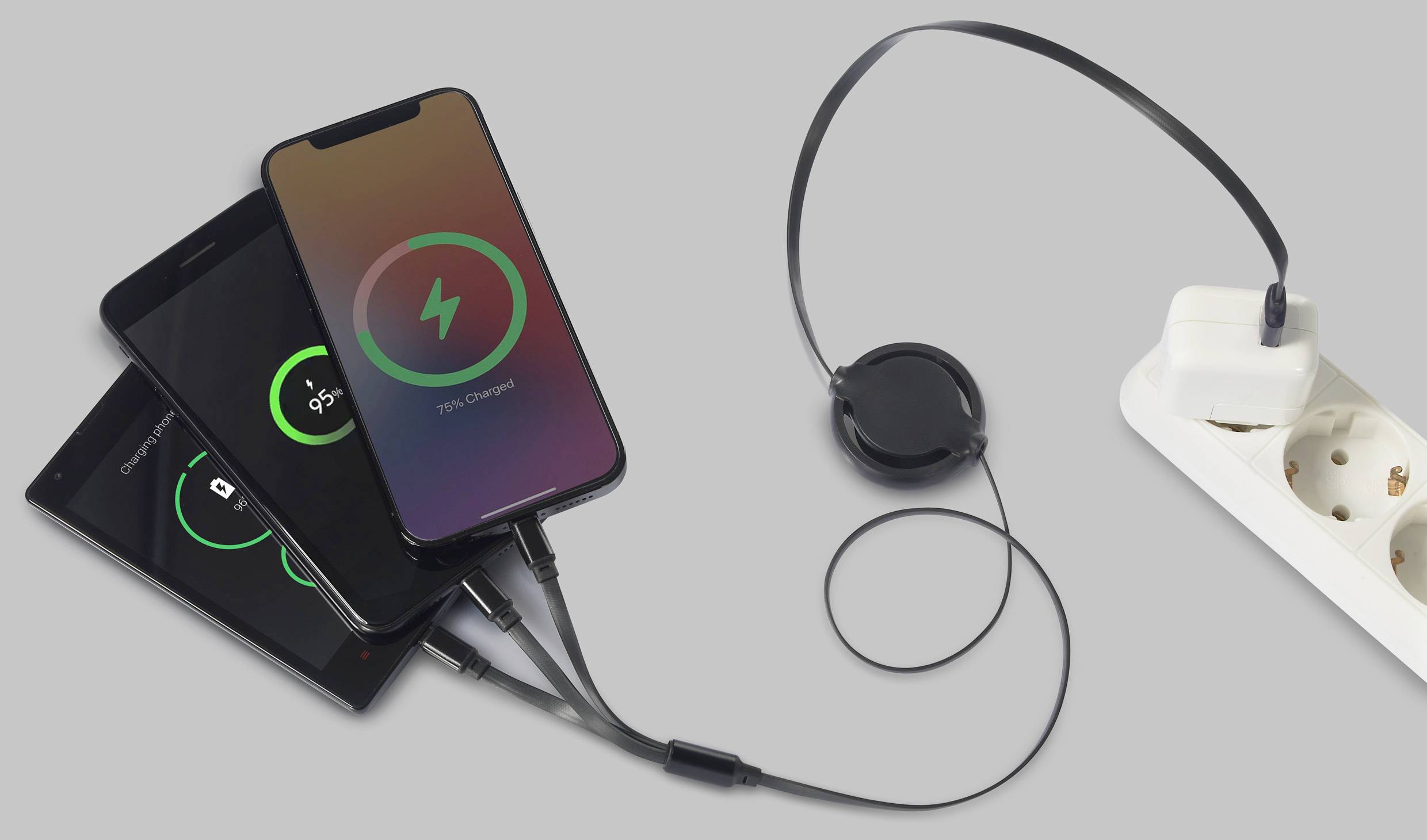 Drei Smartphones laden mit einem USB-Hub an einer Steckdose. Ladeanzeigen auf Bildschirmen zeigen Fortschritt.