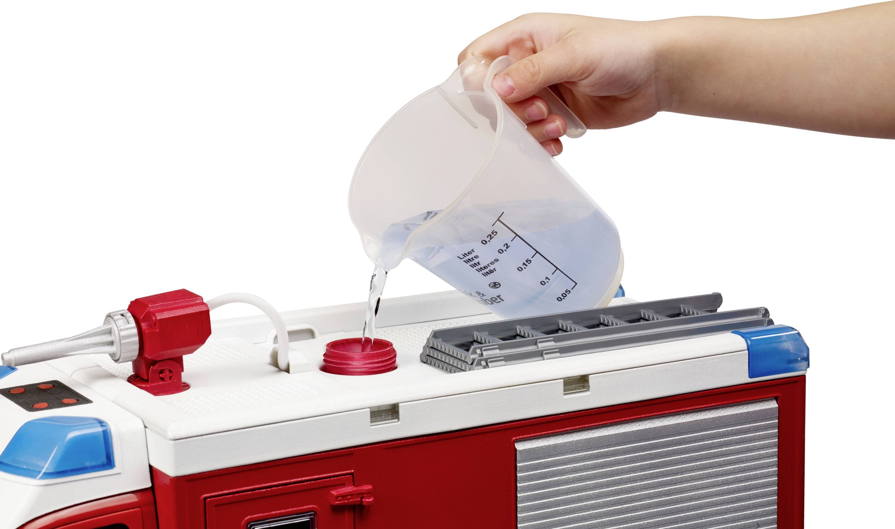 Ein Kind gießt Wasser aus einem Messbecher in ein Spielzeug-Feuerwehrauto.