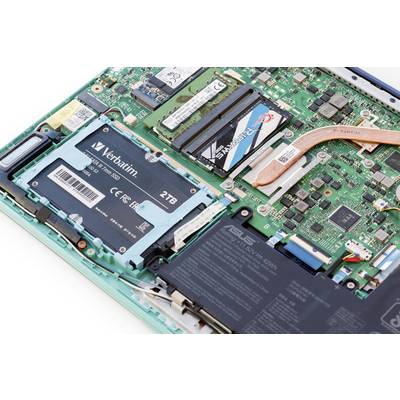 Nahaufnahme einer Computerplatine mit offenem Laptop-Innenleben, zeigt RAM-Module, eine 2-TB-SSD und verschiedene elektronische Komponenten.