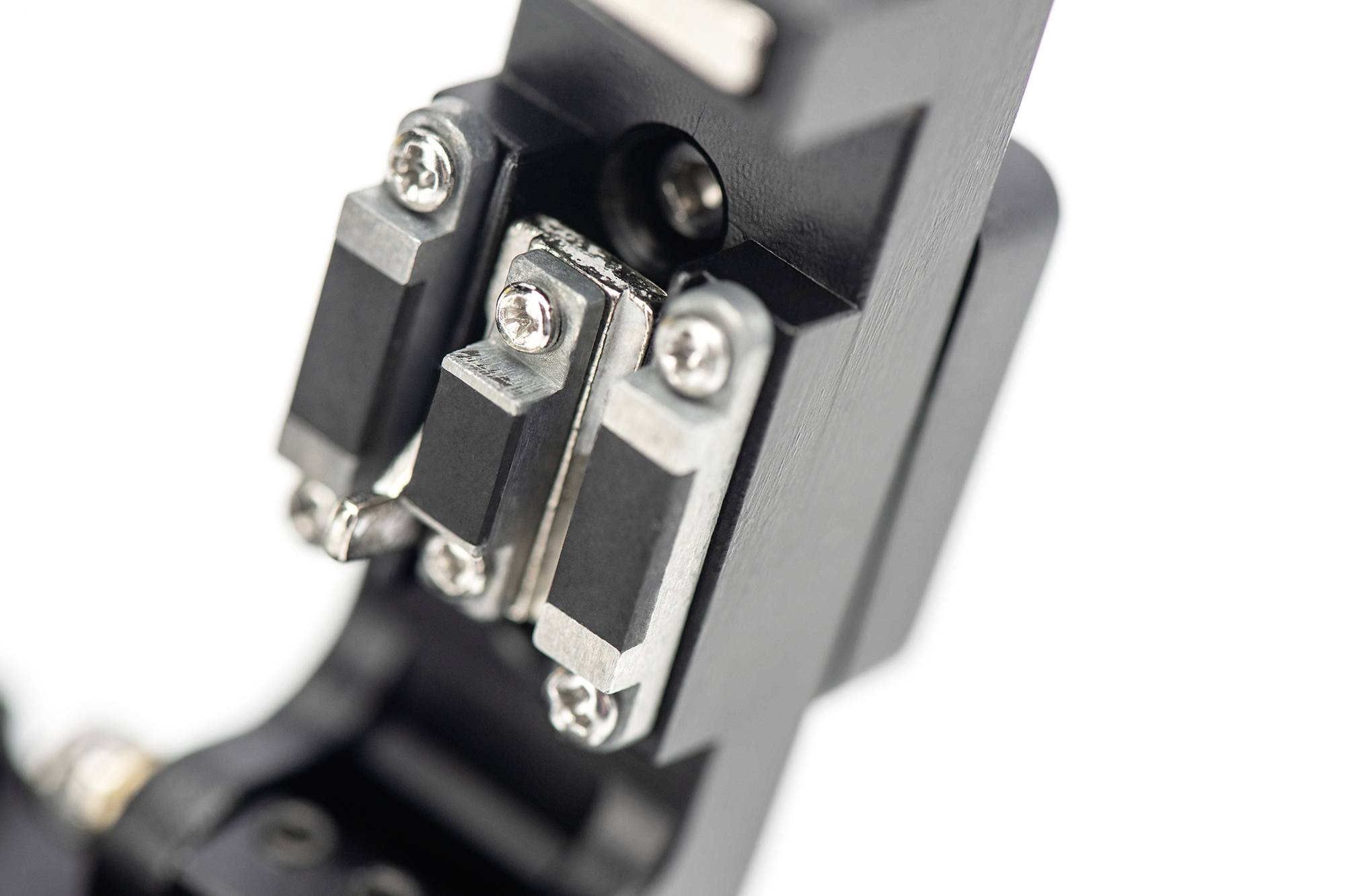 Nahaufnahme eines mechanischen Teils mit mehreren Schrauben und metallischen Komponenten, möglicherweise Teil eines größeren Geräts oder einer Maschine.