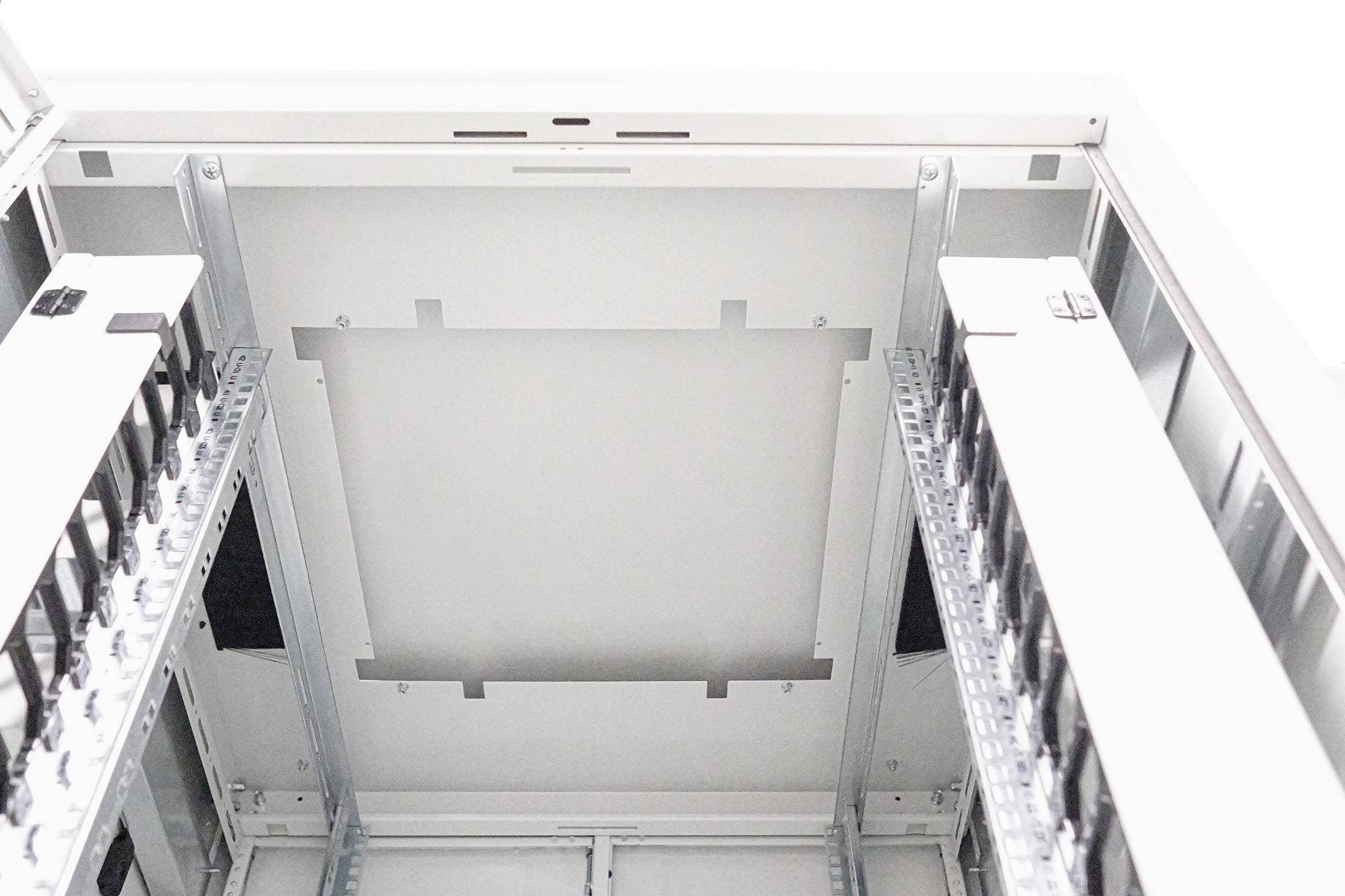 Ein leerer Serverschrank von unten fotografiert, ohne Kabel oder Geräte, zeigt Streben und Schienen zur Montage von Hardware.