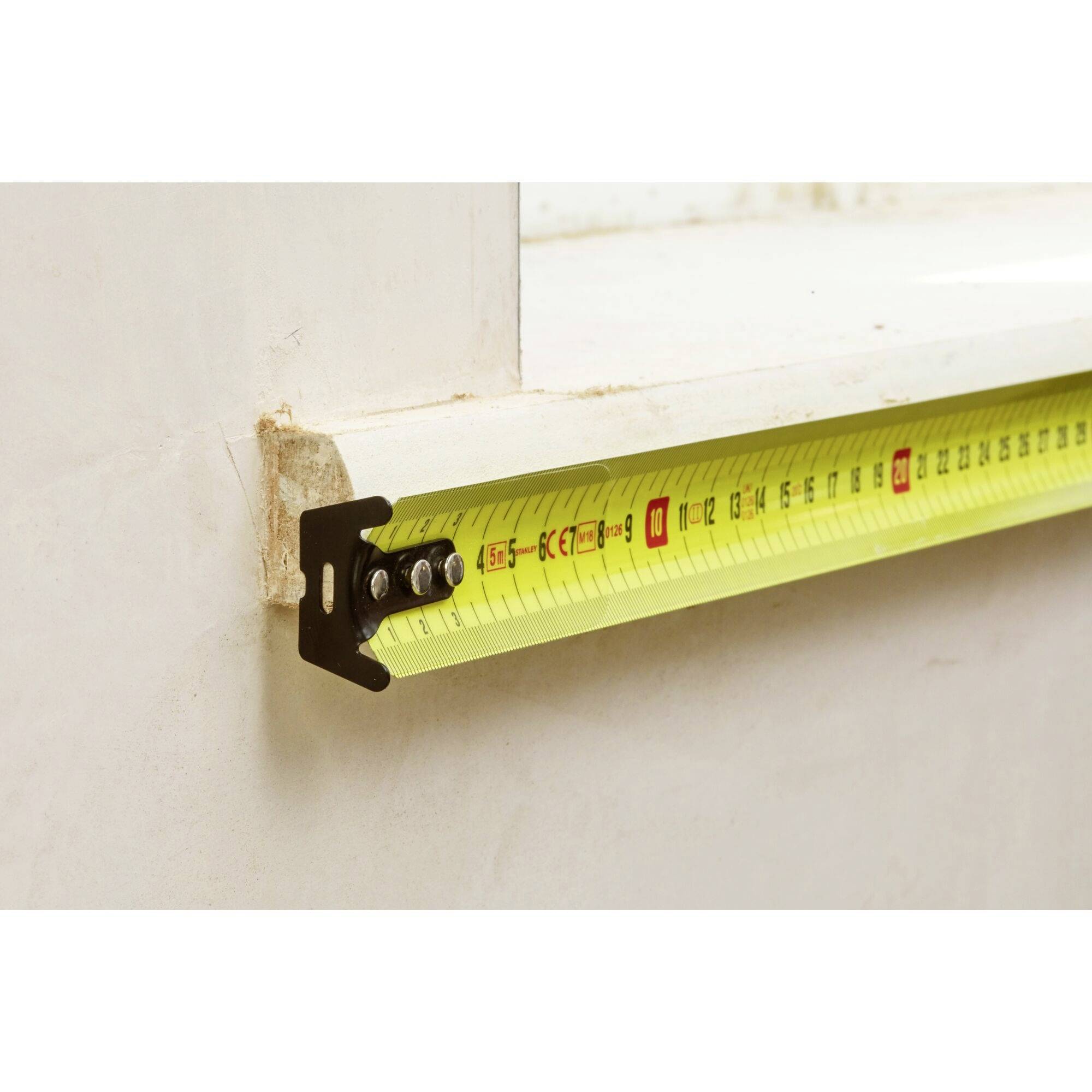 Ein gelbes Maßband mit schwarzem Gehäuse ist auf einem Fensterbrett platziert und zeigt eine Länge von 80 cm an.