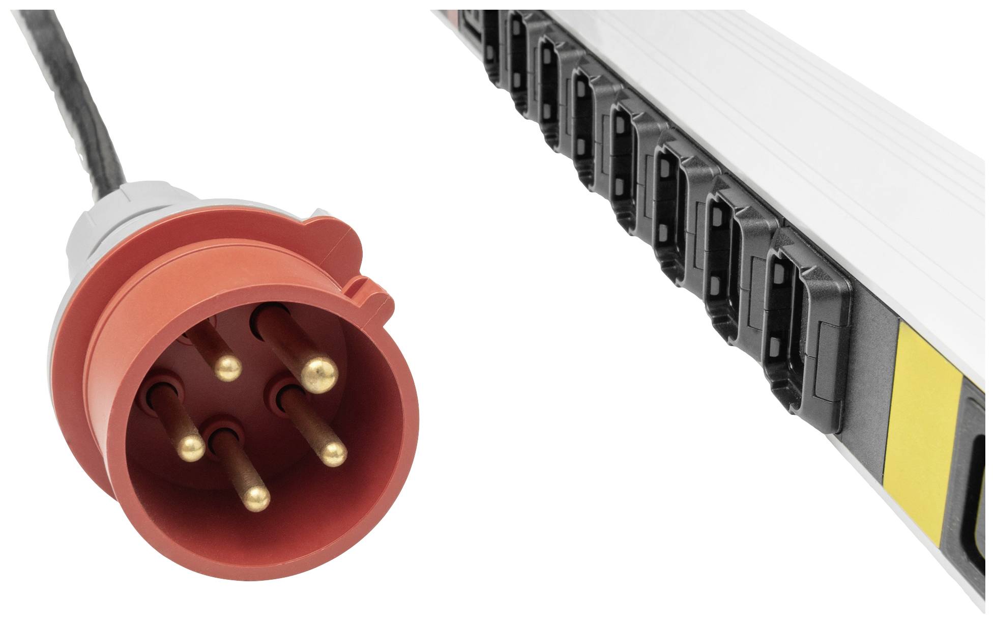 Ein roter Stecker mit fünf Polen neben einer Steckdosenleiste mit mehreren Anschlüssen.