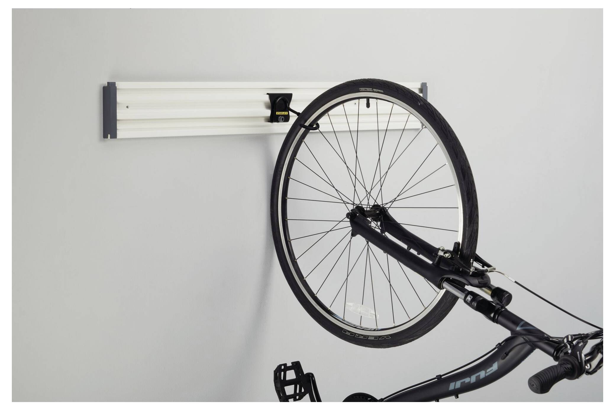 Fahrrad an einer Wandhalterung befestigt, das Vorderrad zeigt nach rechts. Geeignet zur platzsparenden Aufbewahrung.