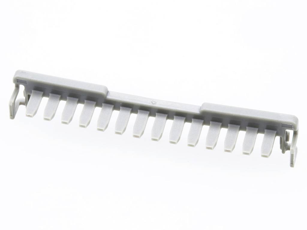Eine graue Plastikabdeckung mit mehreren gleichmäßigen Zähnen, wahrscheinlich Teil eines elektrischen oder mechanischen Geräts.