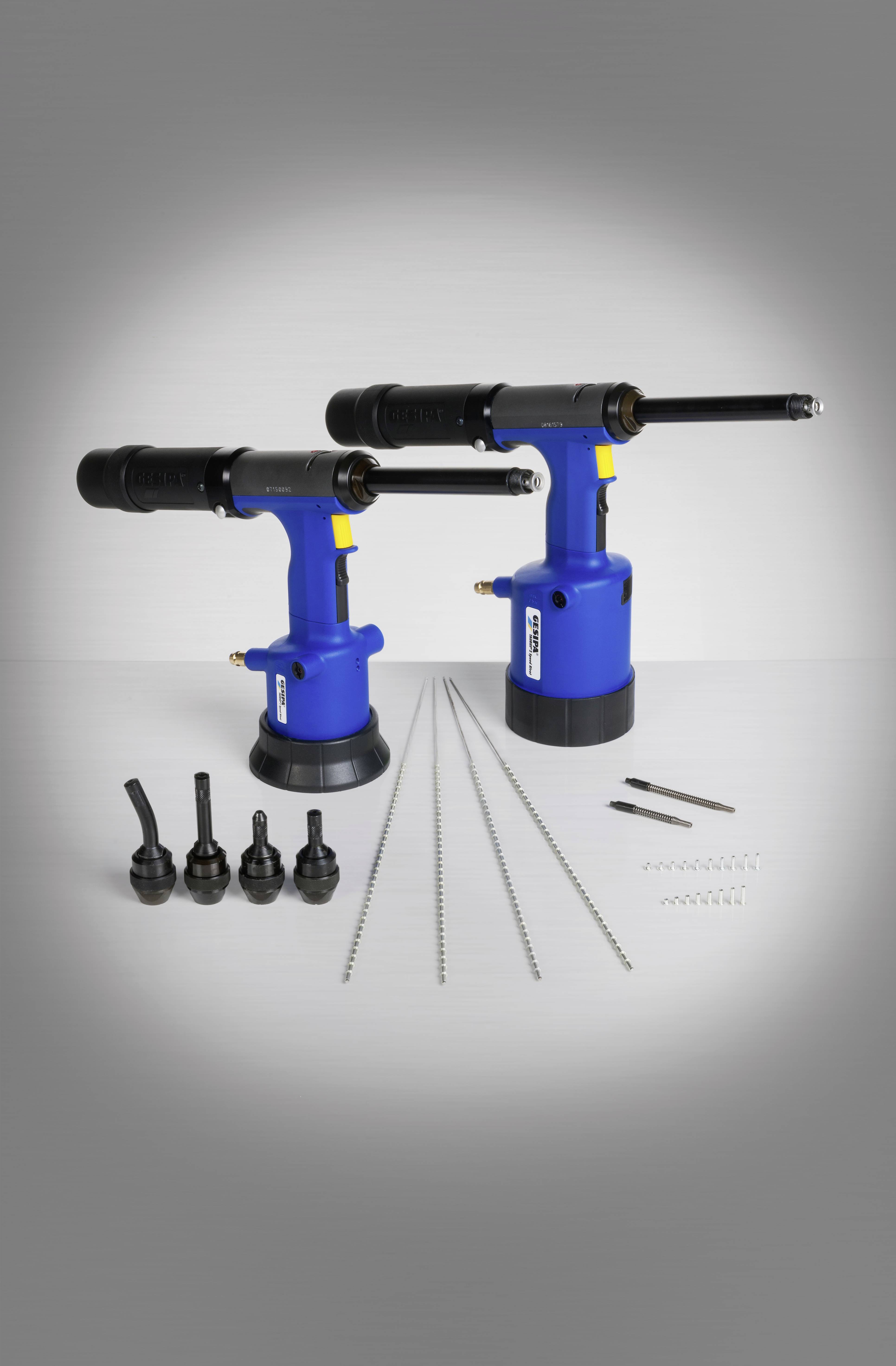 Zwei blaue Druckluftwerkzeuge auf weißem Hintergrund, umgeben von Aufsätzen und Zubehör für Montagearbeiten.