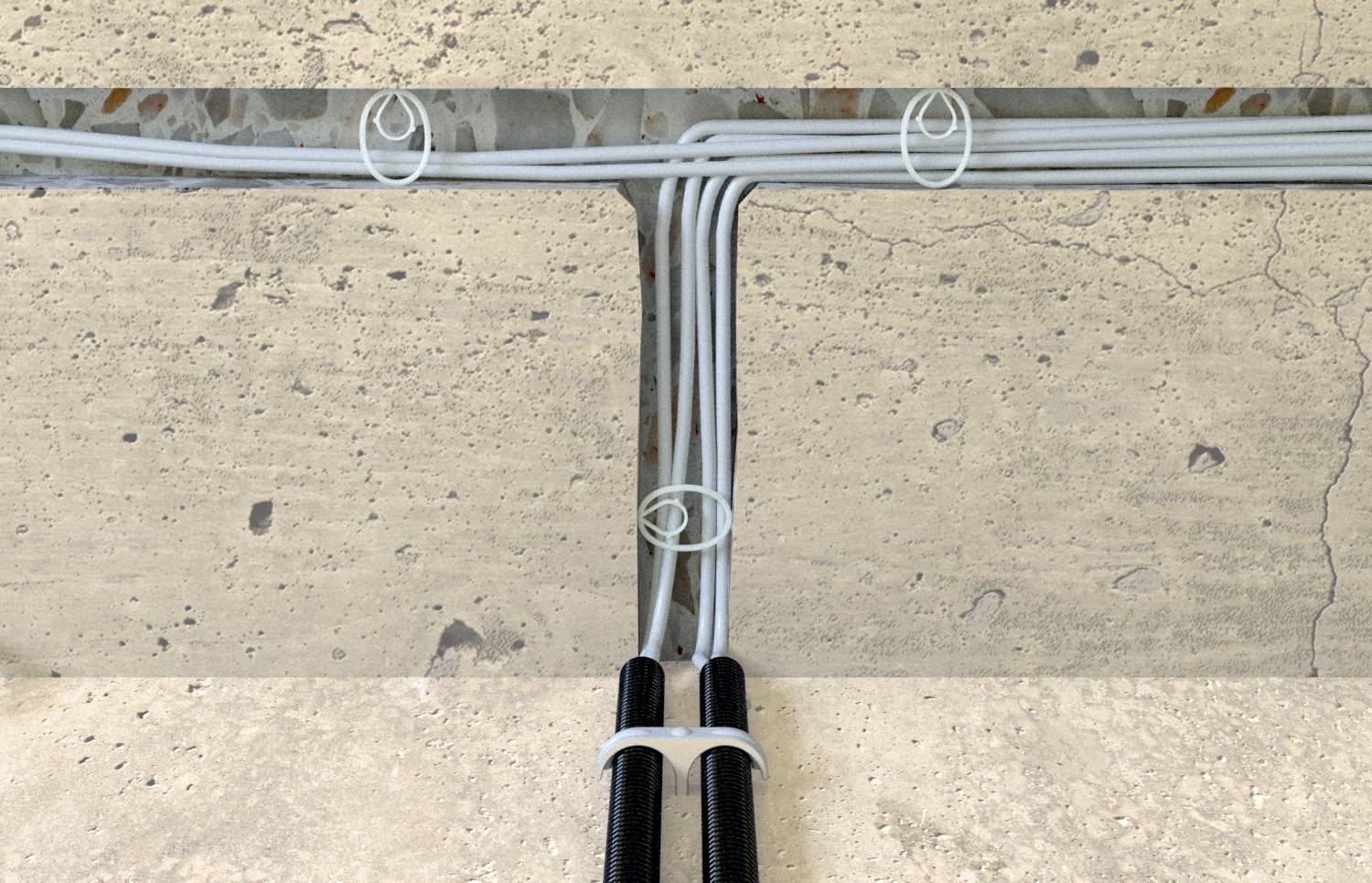 Kabeltrassen entlang einer Betonwand mit sechs grauen Kabeln, die von zwei schwarzen Rohren auf zwei horizontale Wege verteilt sind.