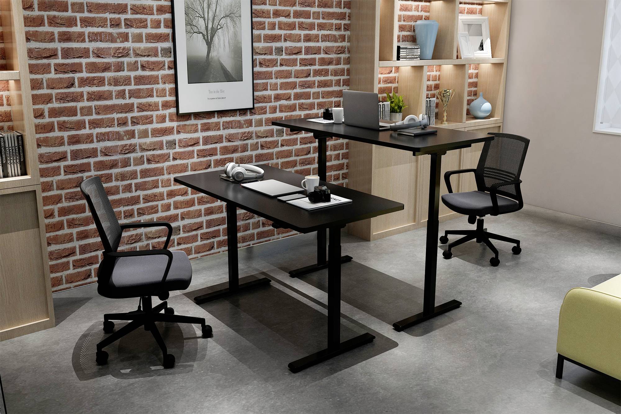 Ein modernes Büro mit zwei schwarzen Schreibtischen, einem im Stehen, einem im Sitzen. Zwei Drehstühle, Regale mit Büchern und Deko.