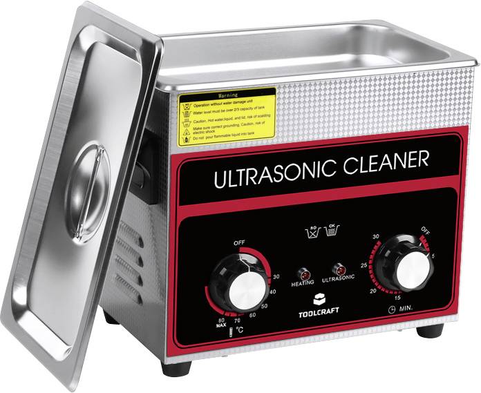 Ein Ultraschallreiniger mit Metallgehäuse, auf dem 'Ultrasonic Cleaner' steht. Zwei Drehknöpfe für Zeit und Heiztemperatur sind sichtbar.
