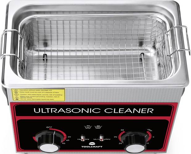 Ultraschallreiniger aus Edelstahl mit Gittereinsatz, zwei Einstellknöpfen und Warnhinweisen auf der Vorderseite.