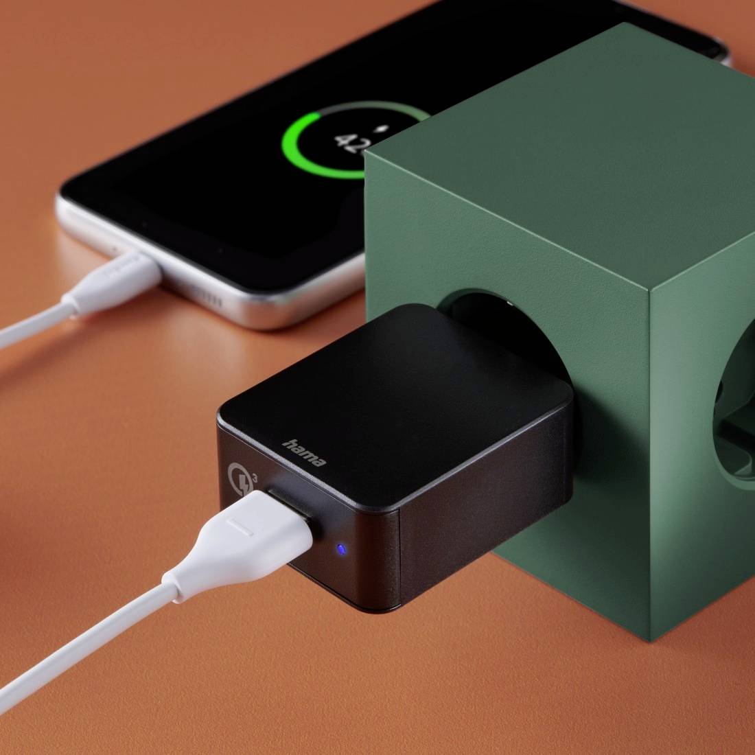 Ein Smartphone wird drahtlos über eine schwarze Ladestation aufgeladen, angezeigt durch ein grünes Ladesymbol auf dem Display.