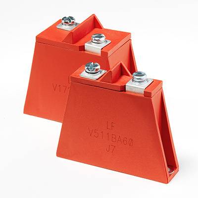 Zwei rote elektrische Isolatoren mit Metallbeschlägen. Einer steht vor dem anderen, beide haben Aufschriften: 'LF V511BA60 J7'.