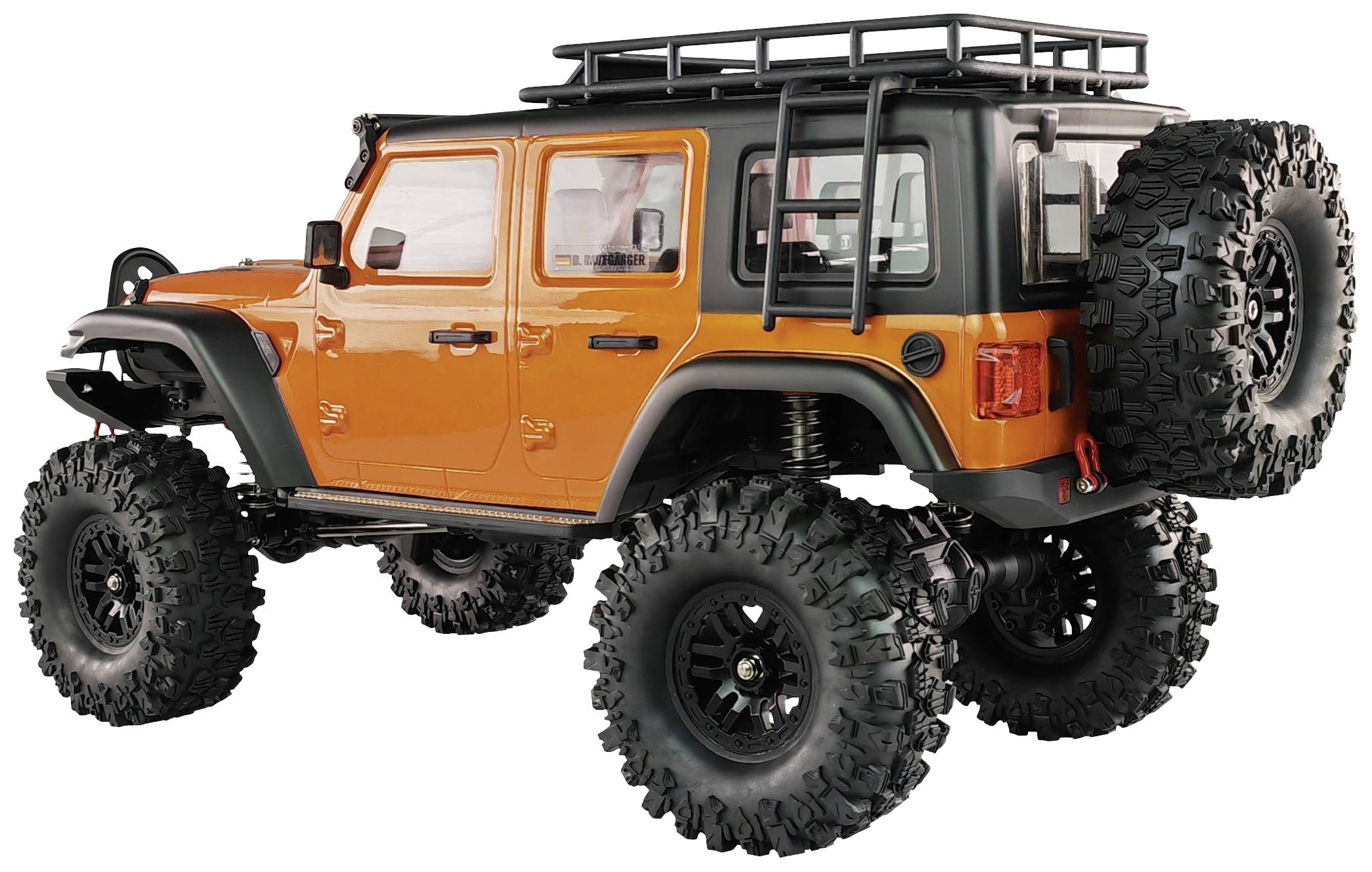 Ein orange-schwarzes Geländewagen-Modell mit großen, robusten Reifen und einem Dachgepäckträger steht in einem Studio.
