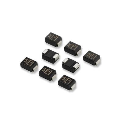 Acht kleine, schwarze elektronische Bauteile mit goldenen Markierungen, gleichmäßig auf einer hellen Oberfläche angeordnet.