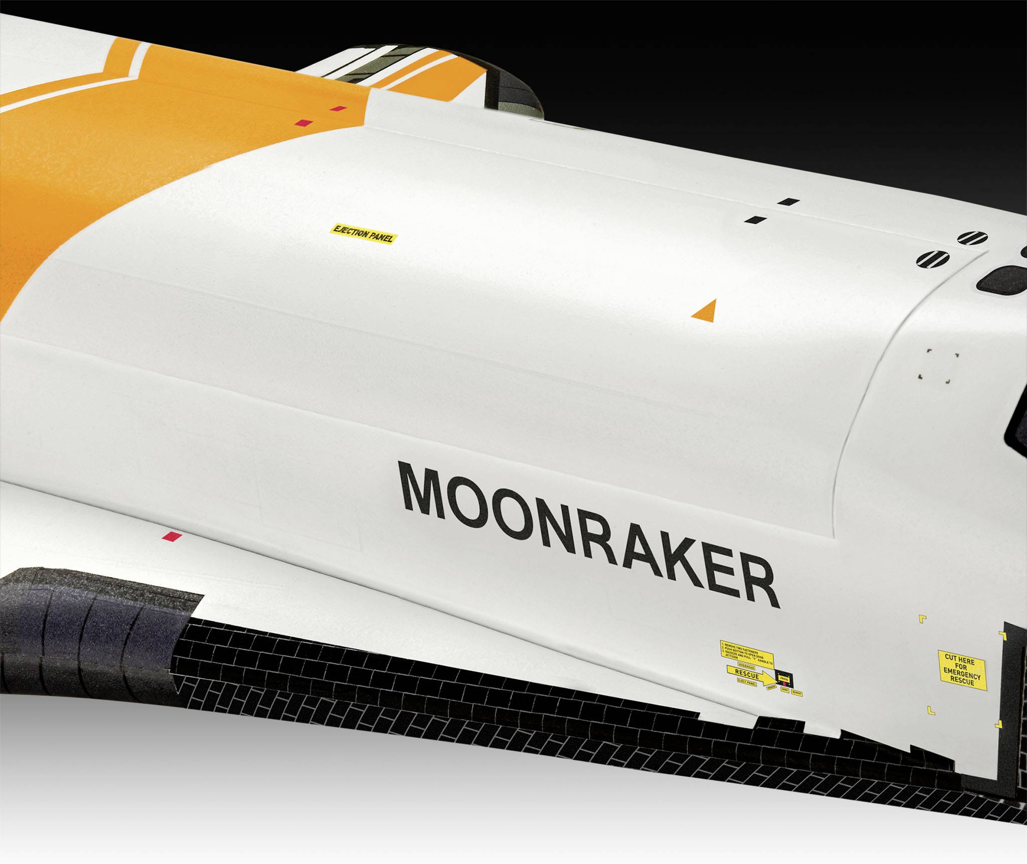 Ein Teil eines weißen Raumfahrzeugs mit der Aufschrift 'MOONRAKER' in schwarzen Buchstaben, auf orangefarbenem Hintergrund.