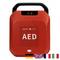 Ein rotes AED-Gerät mit 'OK'-Anzeige oben. Kleine Flaggen von Deutschland, Großbritannien, Frankreich und Italien unten.