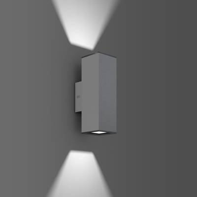 Eine rechteckige Außenleuchte strahlt Licht nach oben und unten auf eine graue Wand, erzeugt einen symmetrischen Lichteffekt.