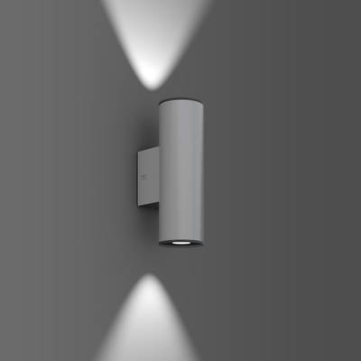Zylindrische Wandlampe mit direktem und indirektem Lichtstrahl auf grauem Hintergrund.
